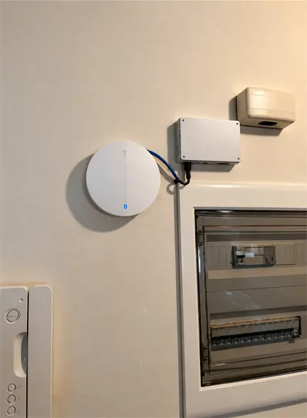 Ceiling Wi-Fi access point beside an electrical board